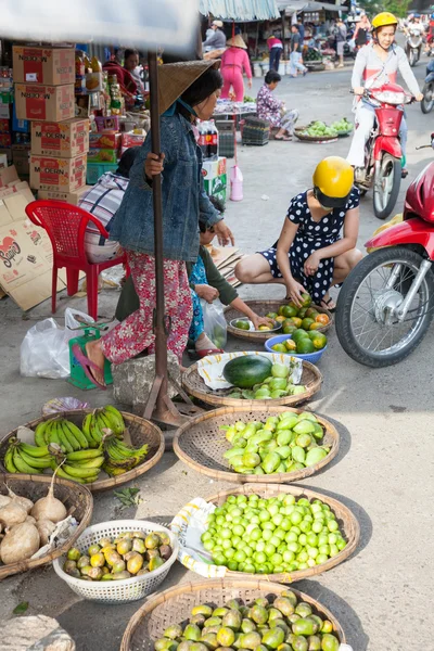Woman picks oranges at the wet market
