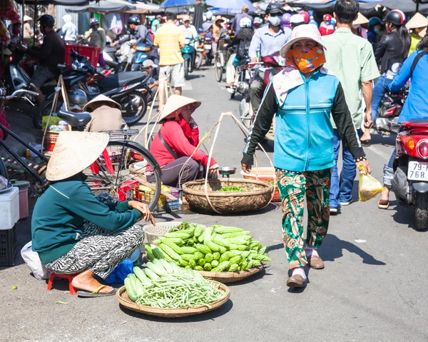 Women are selling greens at the crowded market street