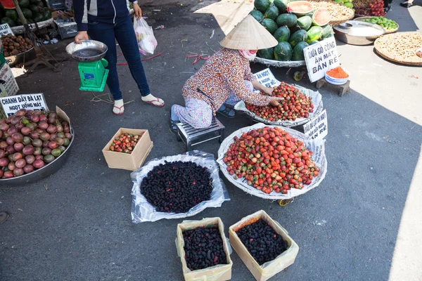 Woman is selling strawberry and mulberry at the wet market