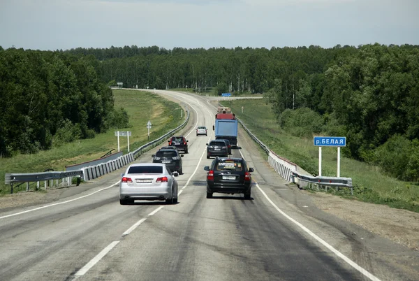 SIBERIA, RUSSIA - JUNE 12, 2012: Cars on The Russian route M52 (R256), also known as Chuya Highway or Chuysky Trakt from Novosibirsk to Russia\'s border with Mongolia