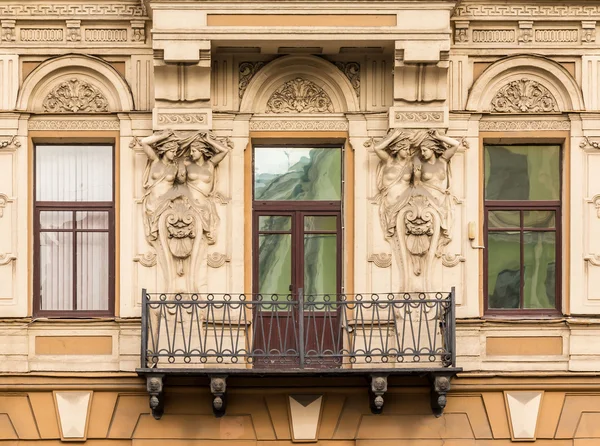 Windows in a row, balcony and sculptures on facade of office building