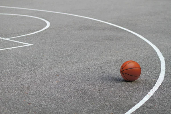 Basketball lying on asphalt