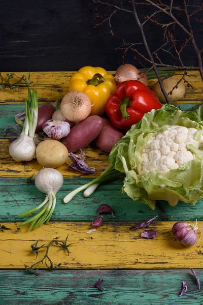 Various vegetables. Cauliflower, pepper, potatoes over colorful wooden table. View from above, copy space.