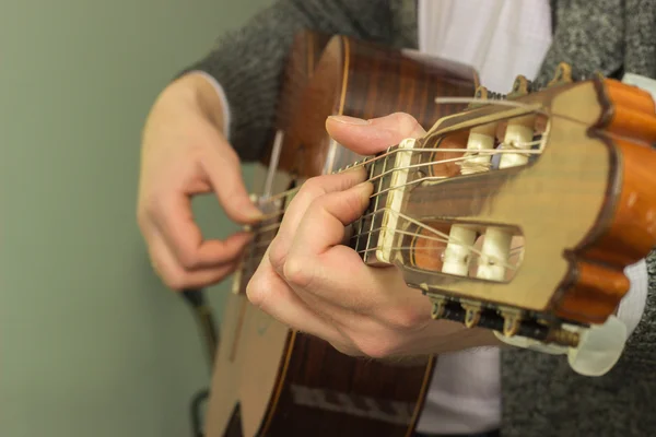 The fingers on the strings of a guitar playing