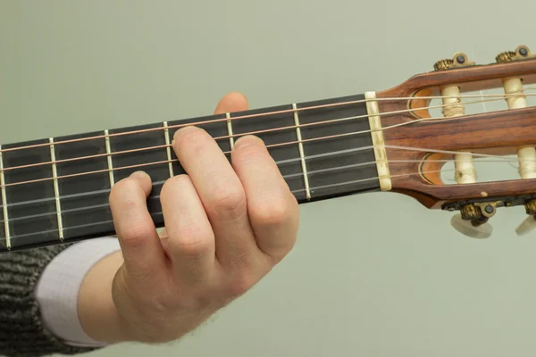 The fingers on the strings of a guitar playing