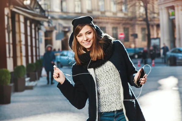 Girl wearing headphones on the street