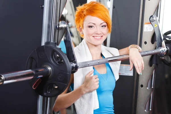 Sport girl with red short hair in gym and smiling