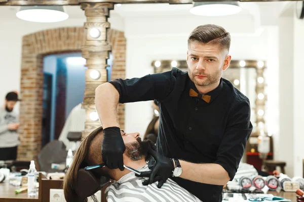 Barber making beard form for man
