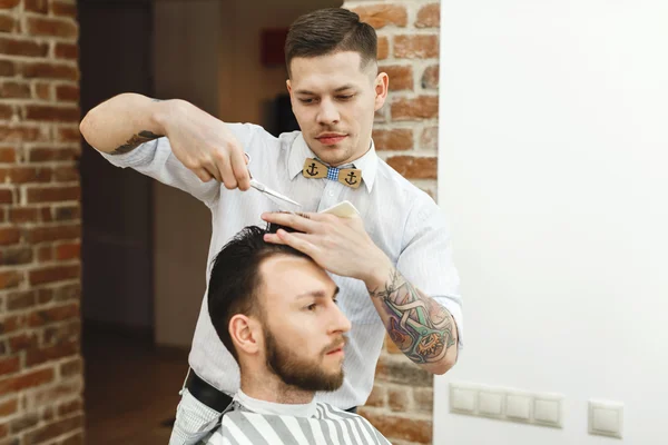 Man with dark hair doing a haircut