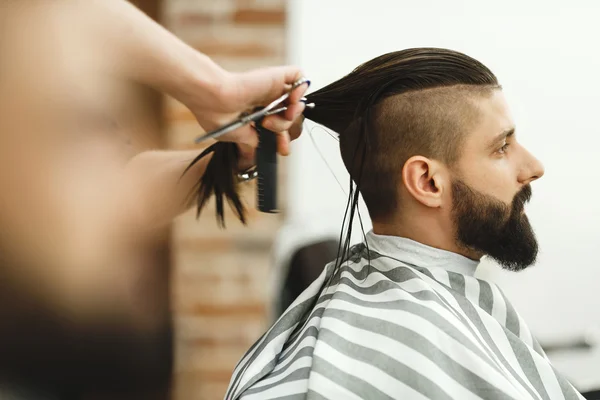 Man with dark hair doing a haircut