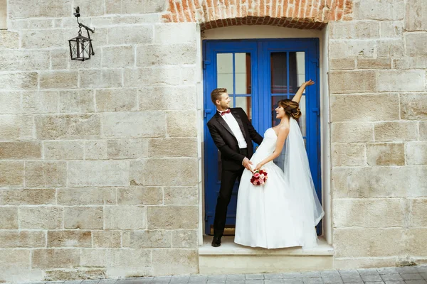 Bride and groom standing near blue door