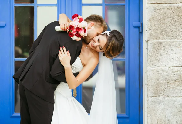 Married couple embracing near blue door