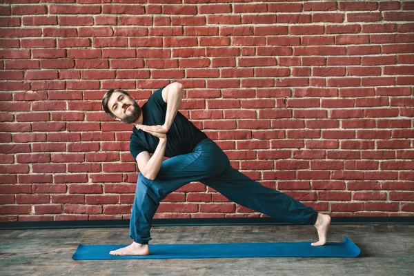 Handsome man doing yoga positions