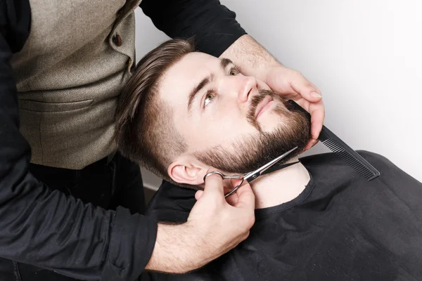 Hairdresser cutting beard