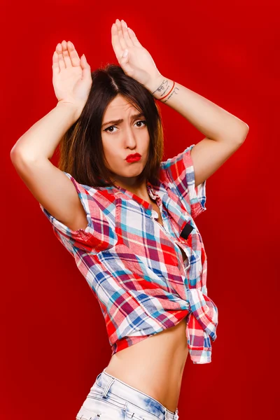 Funny young woman posing with hands over her head