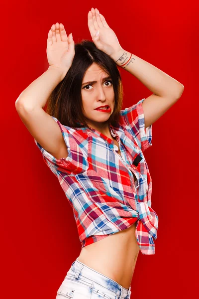 Confused young woman posing with hands over her head