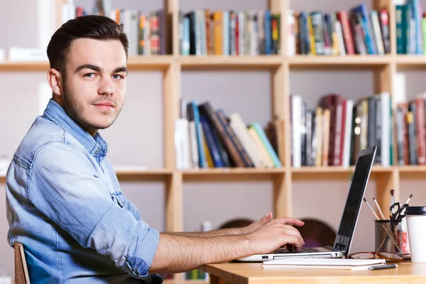 Side view of a handsome man working on laptop