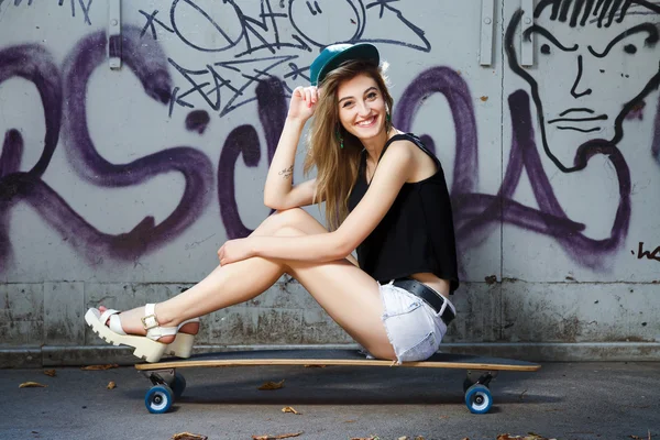 Young woman posing on skateboard