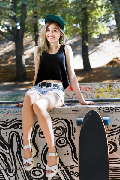 Young woman posing with skate board