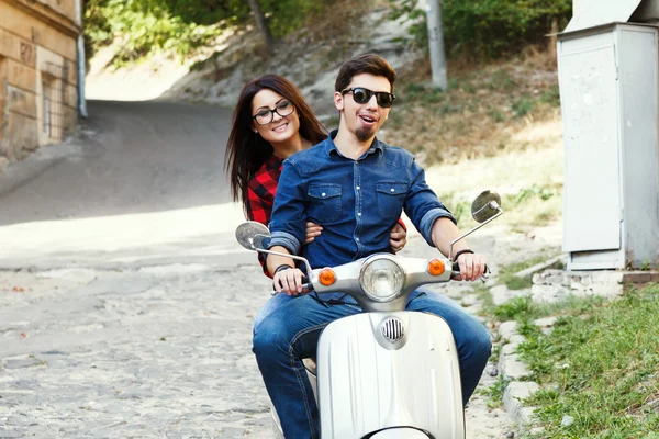 Couple riding on a vintage scooter