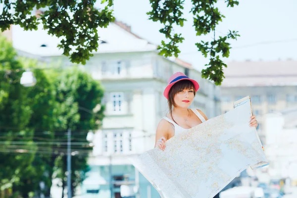 Tourist girl holding a big map