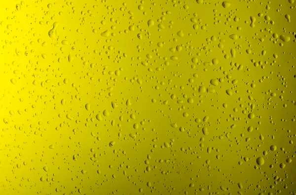 Texture water drops on the yellow bottle close-up as a background.