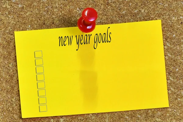 New year goals  word on notepaper with cork background