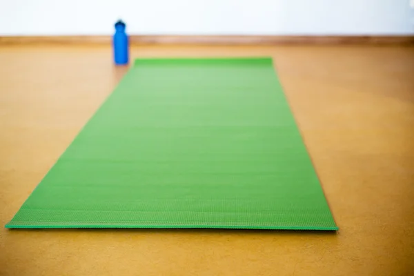Yoga mat, water bottle on yellow  background. Equipment for yoga