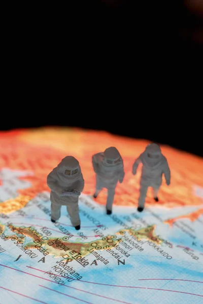 Close up of miniature figurines of astronomers on globe against