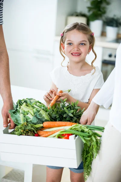 Father and daughter with vegetable box in kitchen