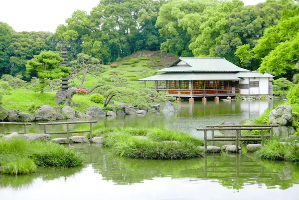 Green hill, bridge, pavilion building in zen garden