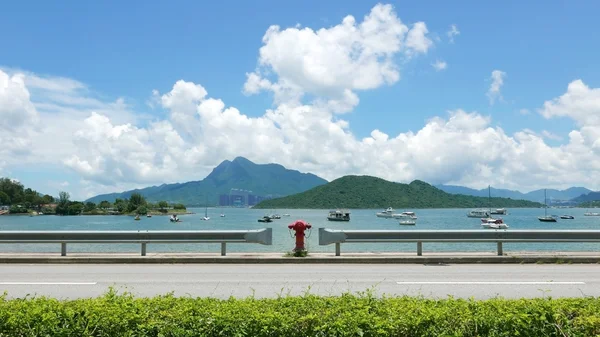 Road, boat, red water pump, lake, blue sky