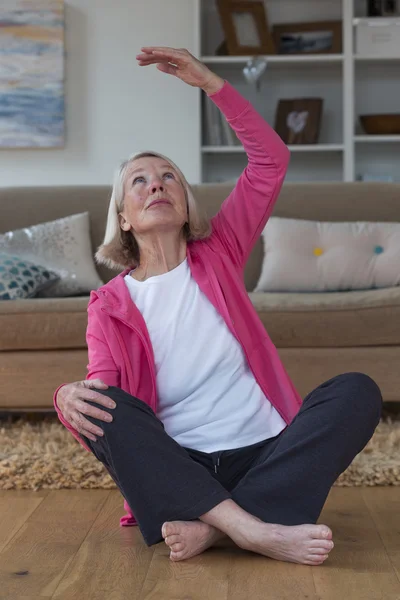 Senior lady stretching at home