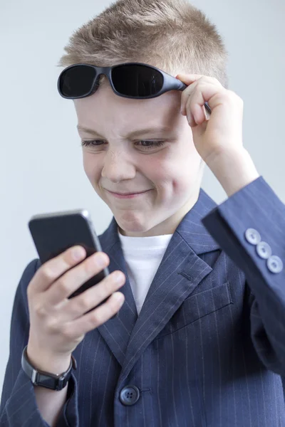 Boy dressed as spy using a smartphone