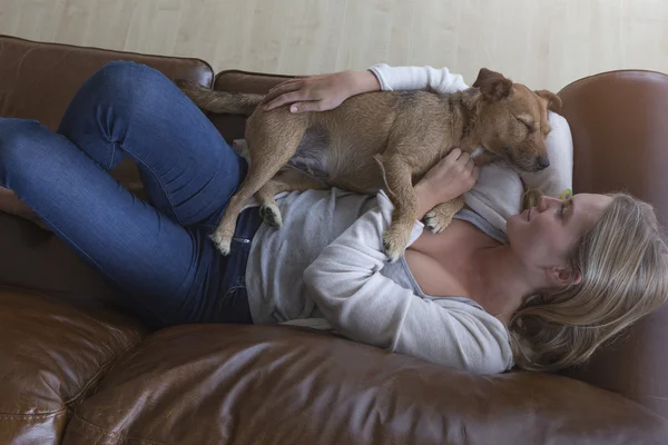 Woman and dog cuddling at home