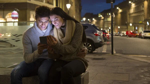 Couple looking at digital tablet in the city