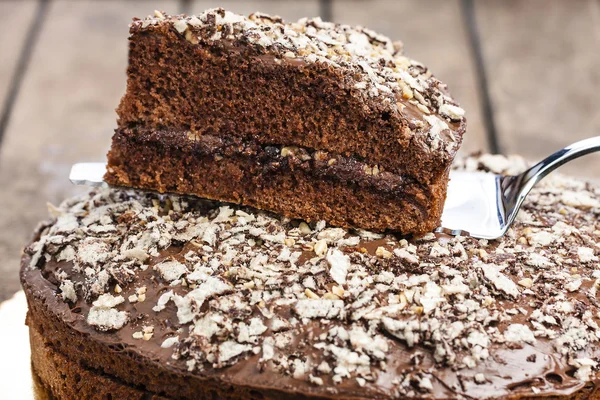 Closeup chocolate dessert slice on silver cake slice on wooden rustic table