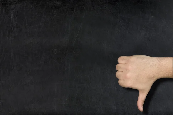 Male hand thumb down on used blank blackboard