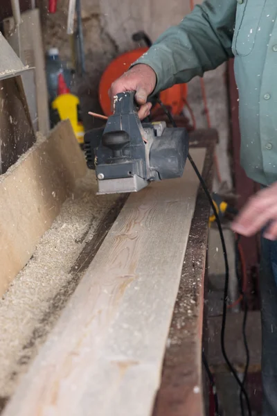 Carpenter works with belt sander in carpentry