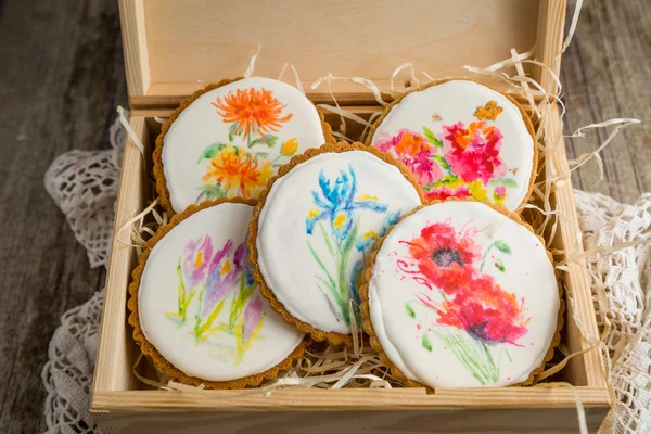 Selection of beautiful cookies with painted flowers in wood box