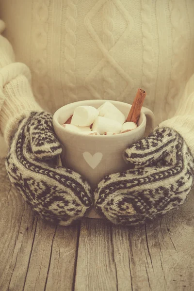 Hands in mittens holding hot chocolate