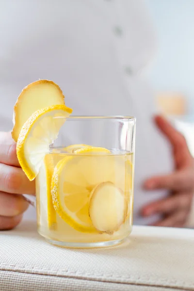 Pregnant holding ginger and lemon tea