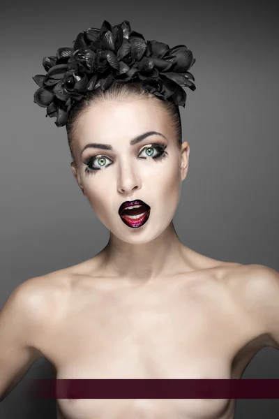 Beautiful fashion model topless with great makeup, lipstick, eyebrows hairstyle and black flower