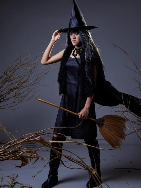 Woman in costume of witch with broom