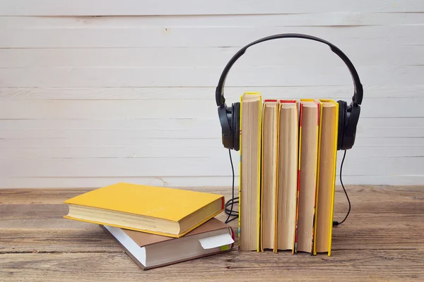 Audio book concept, yellow books and headphones over white backg