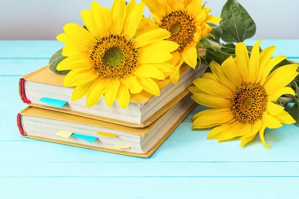 Background with sunflowers and yellow book on blue wooden boards