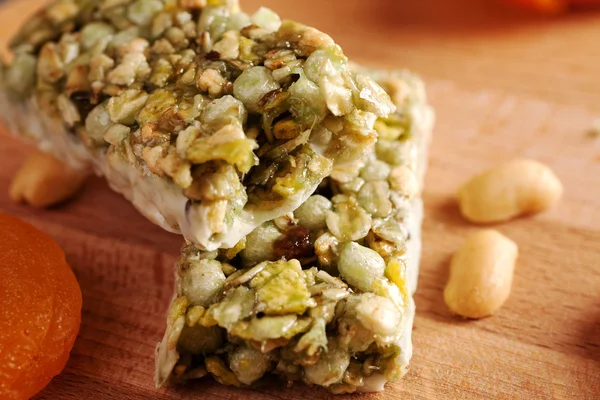 Granola bar on wooden board with dried fruits and nuts