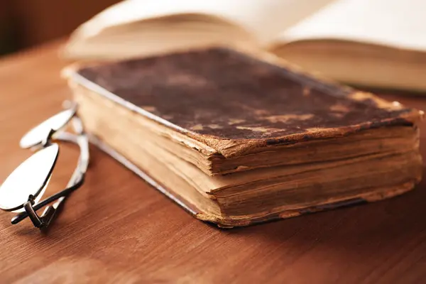 Old book in a leather cover on wooden table