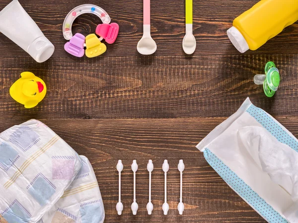 Baby essentials and care on dark wooden table with copy space