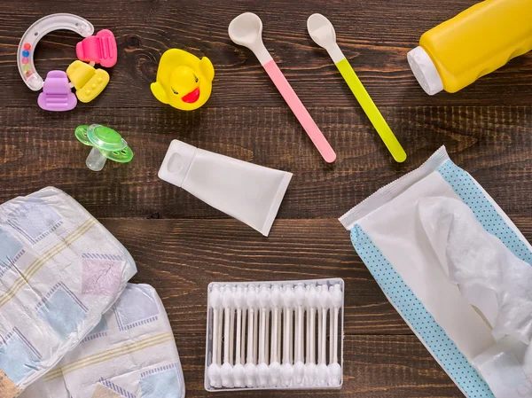 Baby essentials and care on dark wooden table